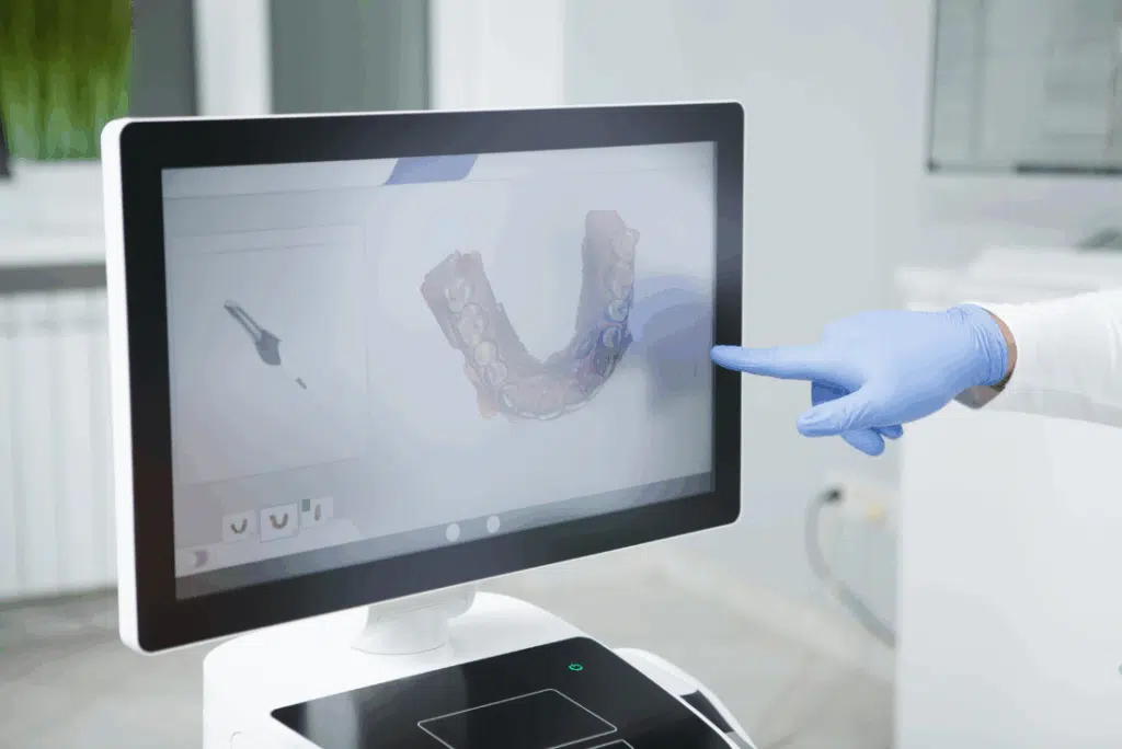 Pediatric Dentist In Great Neck, Ny: A Parent’s Guide To Expert Dental Care For Kids Digital orthodontic screening display with a dental professional pointing, emphasizing early orthodontic care for children.