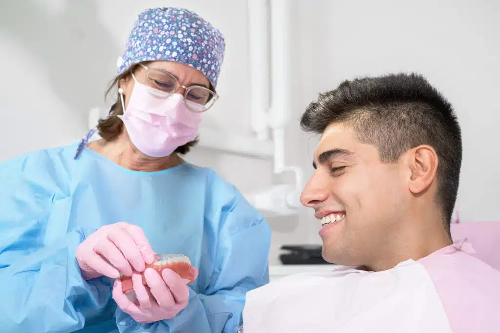 Can I Switch Orthodontists During Treatment? What You Need To Know Orthodontist Holding Invisible Retainer For Teeth Alignment